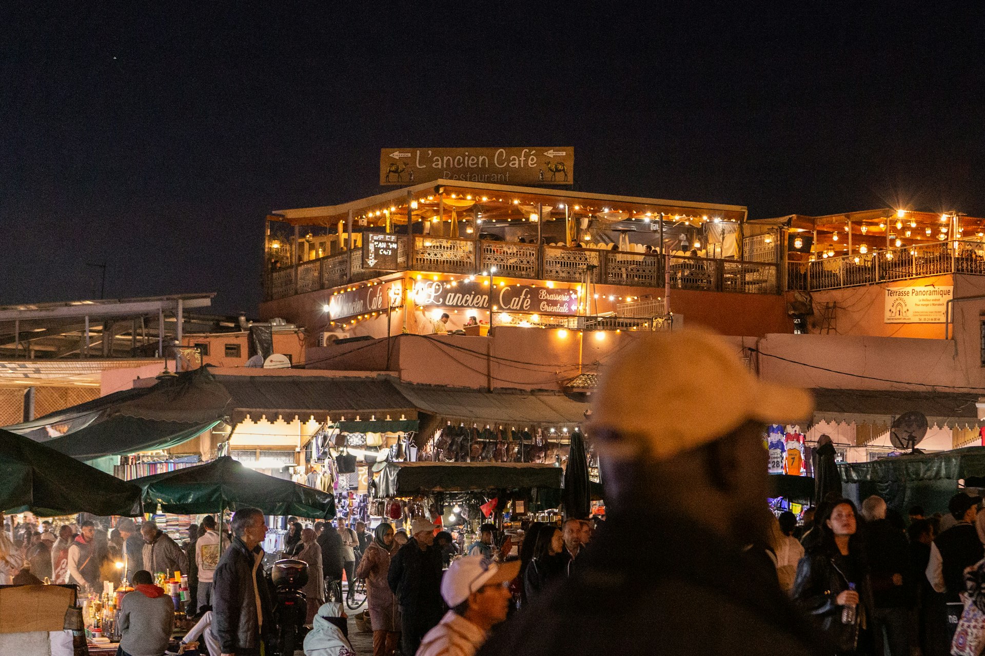 A crowd of people standing around a market at night